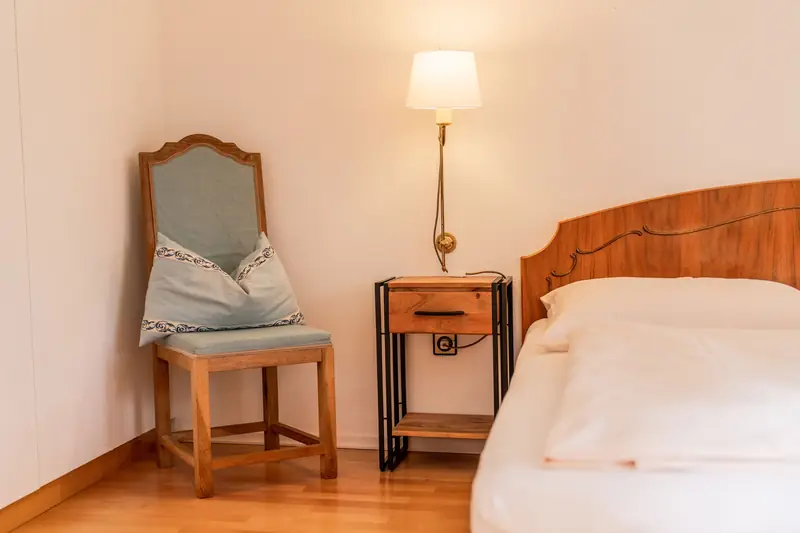 Schlafzimmer mit Holzbett und Nachttischlampe