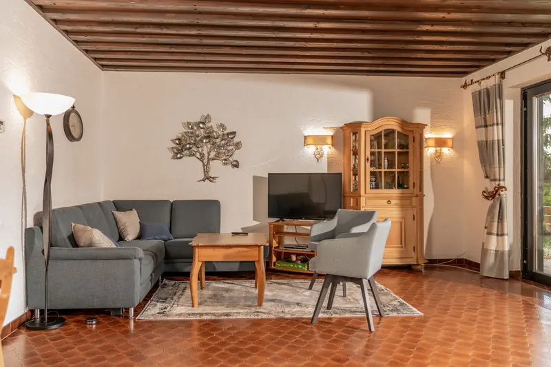 Wohnzimmer mit grauer Sofaecke und Bauernschrank